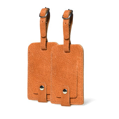 Two brown leather luggage tags on a white background