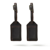 Two brown leather luggage tags on a white background