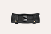 Black leather tool roll with metallic accents on a light beige background