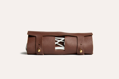 Brown leather roll with white laces on a beige background