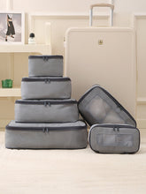 Set of gray packing cubes with a suitcase on a light-colored floor.