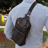 Person wearing a black leather crossbody bag outdoors
