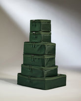 Stack of green packing cubes on a neutral background