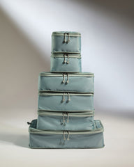Stack of light blue suitcases on a neutral background