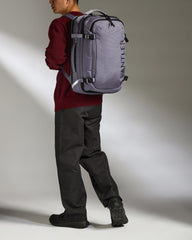 Person wearing a gray Antler backpack against a neutral background