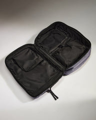 Black travel organizer with compartments on a light gray background