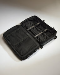 Black suitcase with open compartment on a light gray background