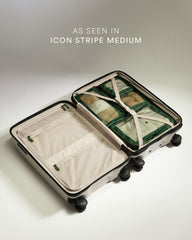 Open suitcase with green packing cubes on a light background