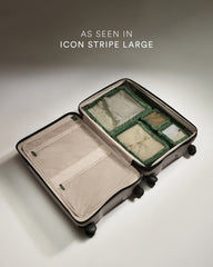 Open suitcase with green packing cubes on a light background
