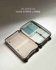 Open suitcase with organized contents on a neutral background, labeled 'Icon Stripe Large'.