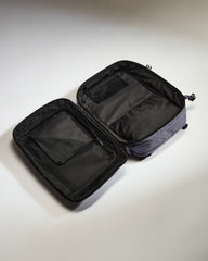 Open black travel bag on a light gray background