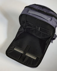 Black backpack with open compartment on a light gray background