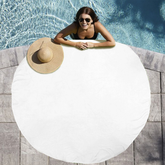 Woman lounging on a white inflatable pool float with a straw hat nearby, by a pool.