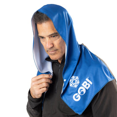 Man wearing a blue towel with 'Gobi' branding over his head on a white background