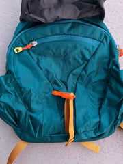 Teal backpack with orange accents on a light gray background