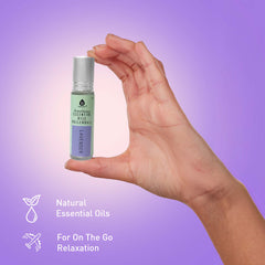 Hand holding a small bottle of essential oils against a purple gradient background
