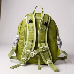 Green backpack with multiple straps and buckles on a light gray background