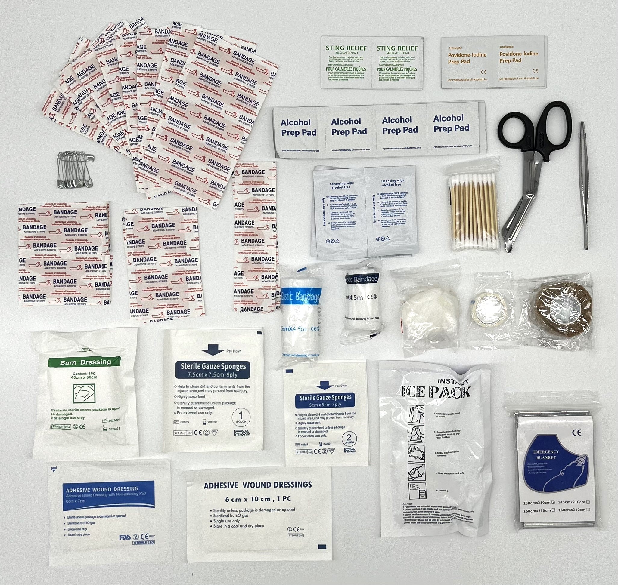First aid kit contents including bandages, alcohol prep pads, scissors, and other medical supplies on a white background.