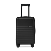 Black suitcase with wheels and handle on a white background