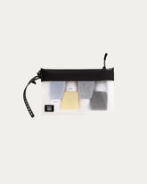 Black travel toiletry bag with various items on a white background