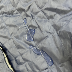 Water droplets on a gray quilted fabric surface