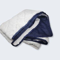 Folded blanket with white sherpa interior and navy border on a light gray background