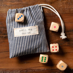 Striped dice bag labeled 'roll 'em dice set' with wooden dice on a wooden surface