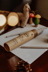 Wooden pencils with a branded wooden holder on a table with decorative items.