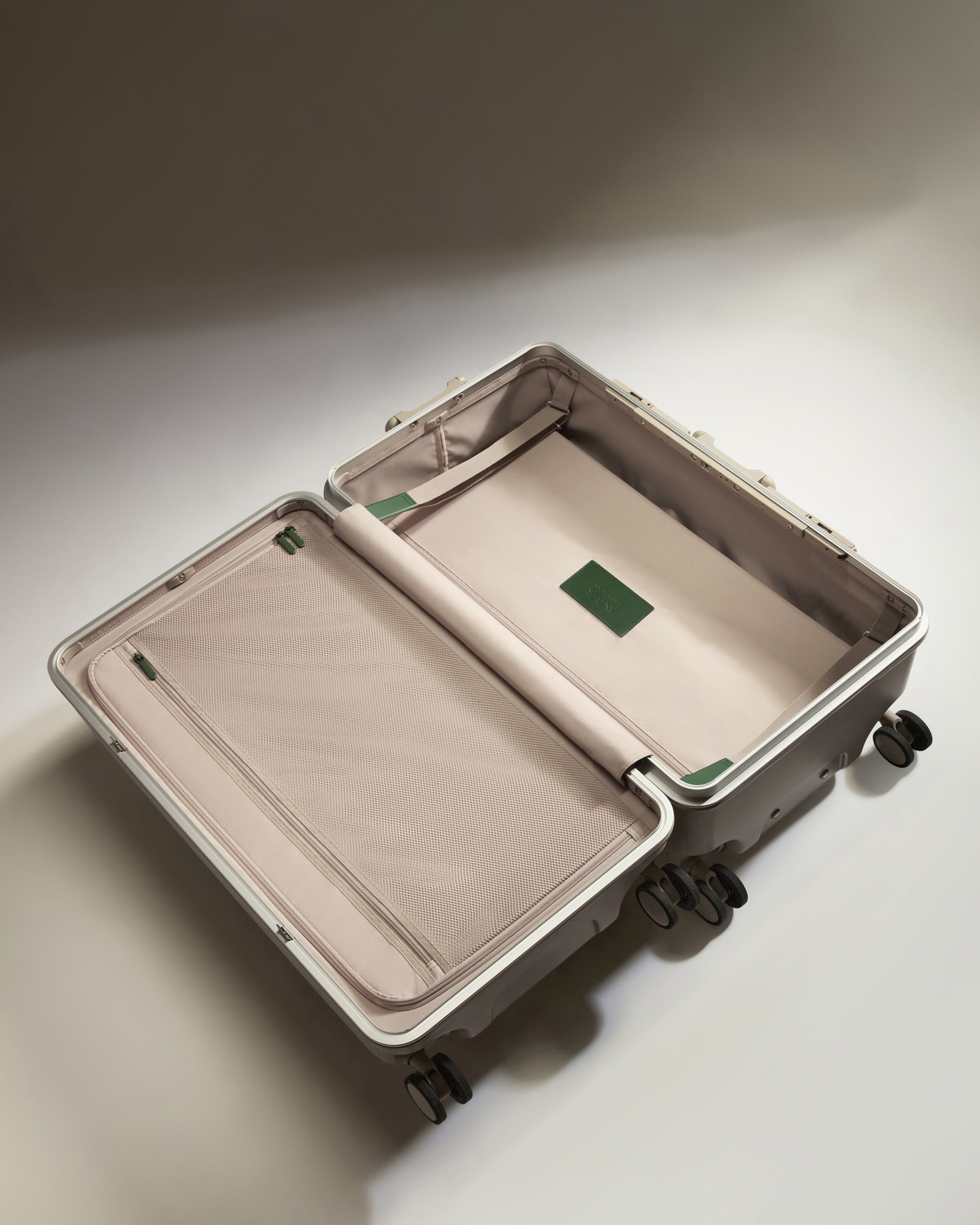 Beige suitcase with open lid on a light gray background