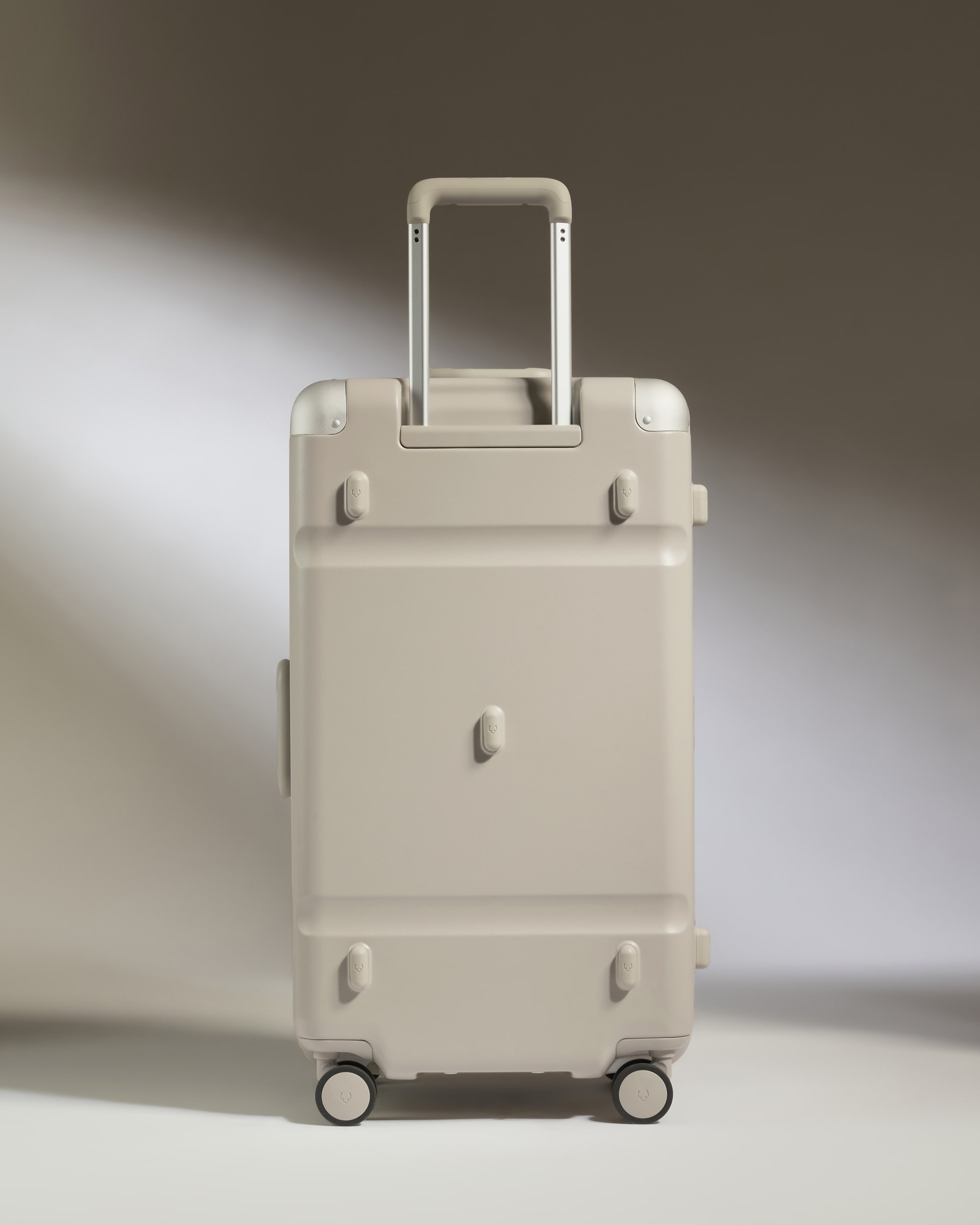 Beige suitcase with wheels on a gradient background