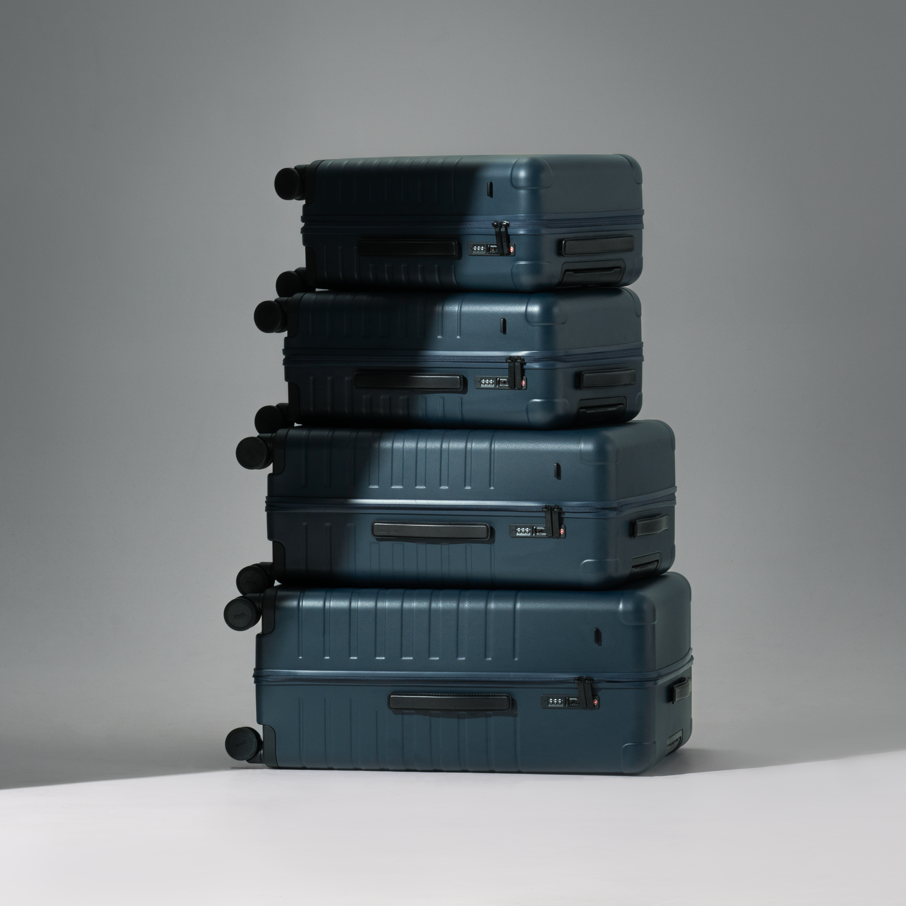 Stack of blue suitcases on a gray background