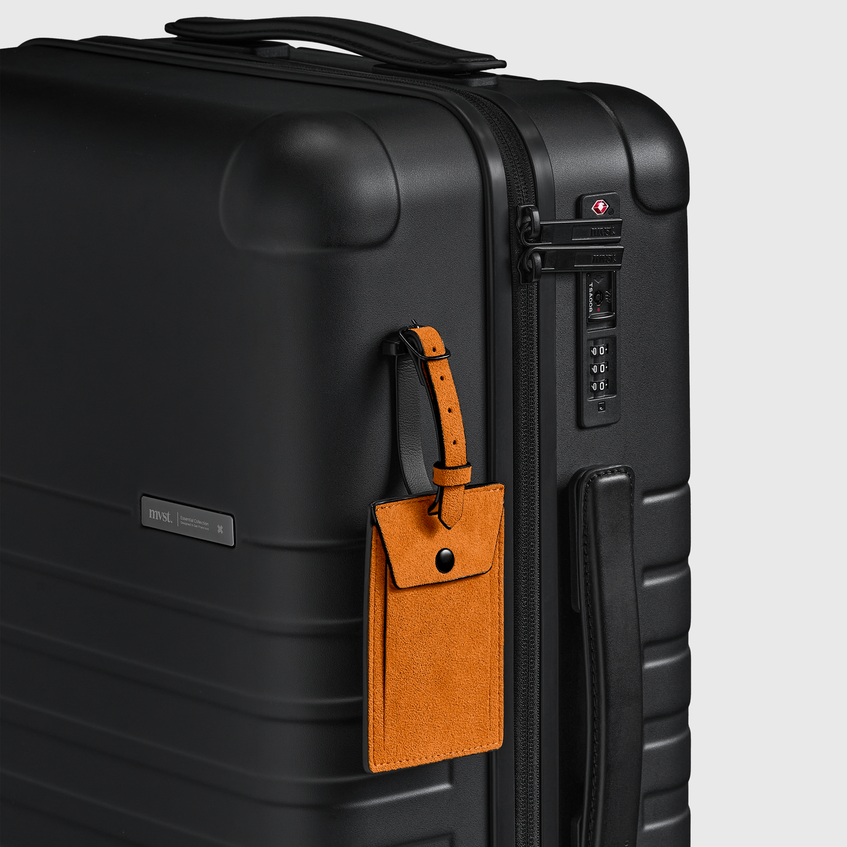 Black suitcase with a brown luggage tag on a light gray background