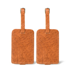 Two brown leather luggage tags on a white background