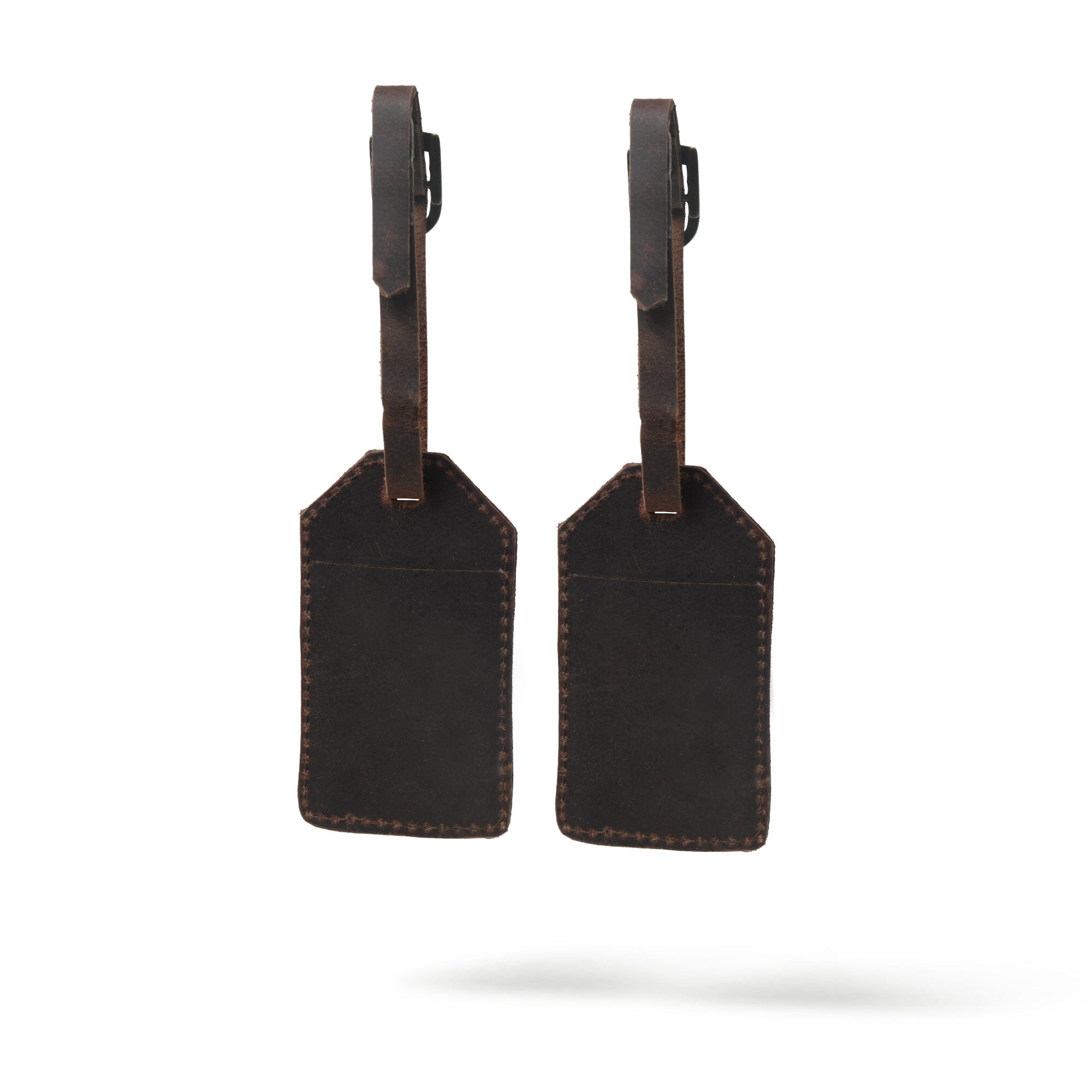 Two black leather luggage tags with brown straps on a white background