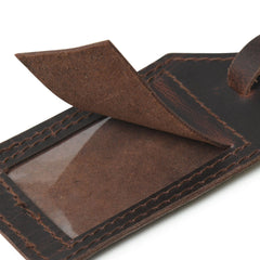 Close-up of a brown leather wallet with a clear card holder on a white background