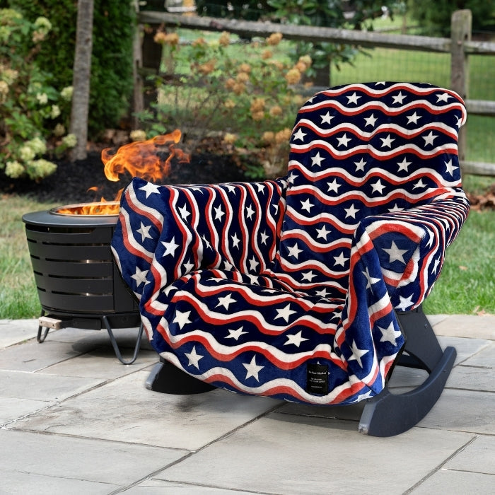 Rocking chair with American flag pattern draped over it on a patio