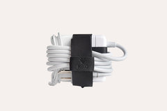 White earbud with black clip on a light gray background