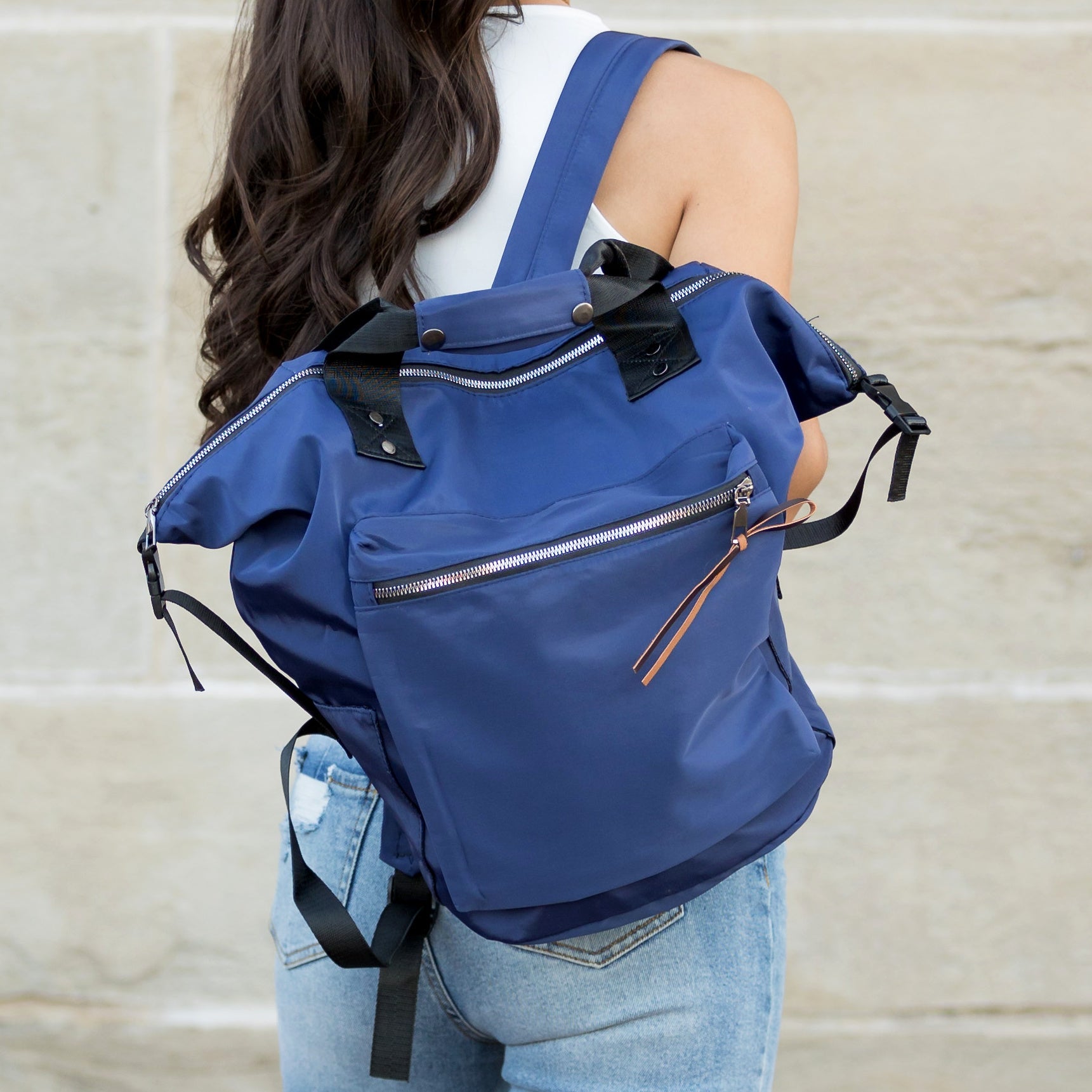 Person wearing a blue backpack with a neutral background