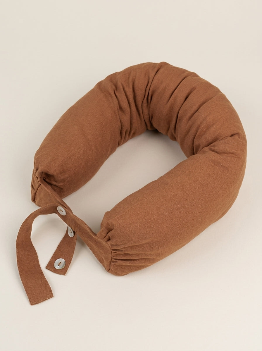 Brown travel pillow on a beige background