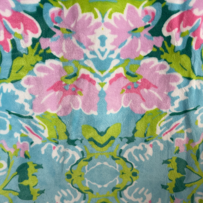 Patterned fabric with pink flowers and green leaves on a blue background