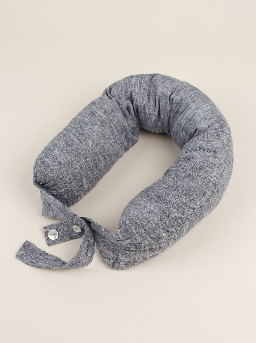 Blue fabric neck pillow on a beige background