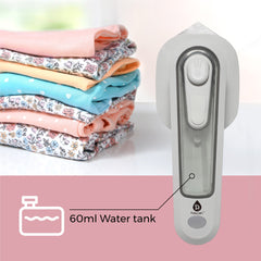 Portable device with 60ml water tank next to folded clothes on a white surface