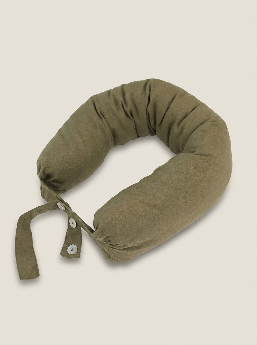 Green travel neck pillow on a beige background