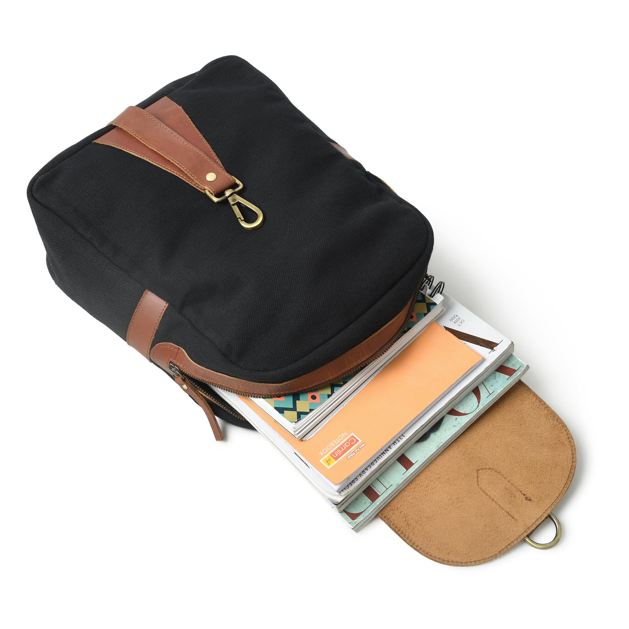 Black backpack with brown accents containing notebooks on a white background