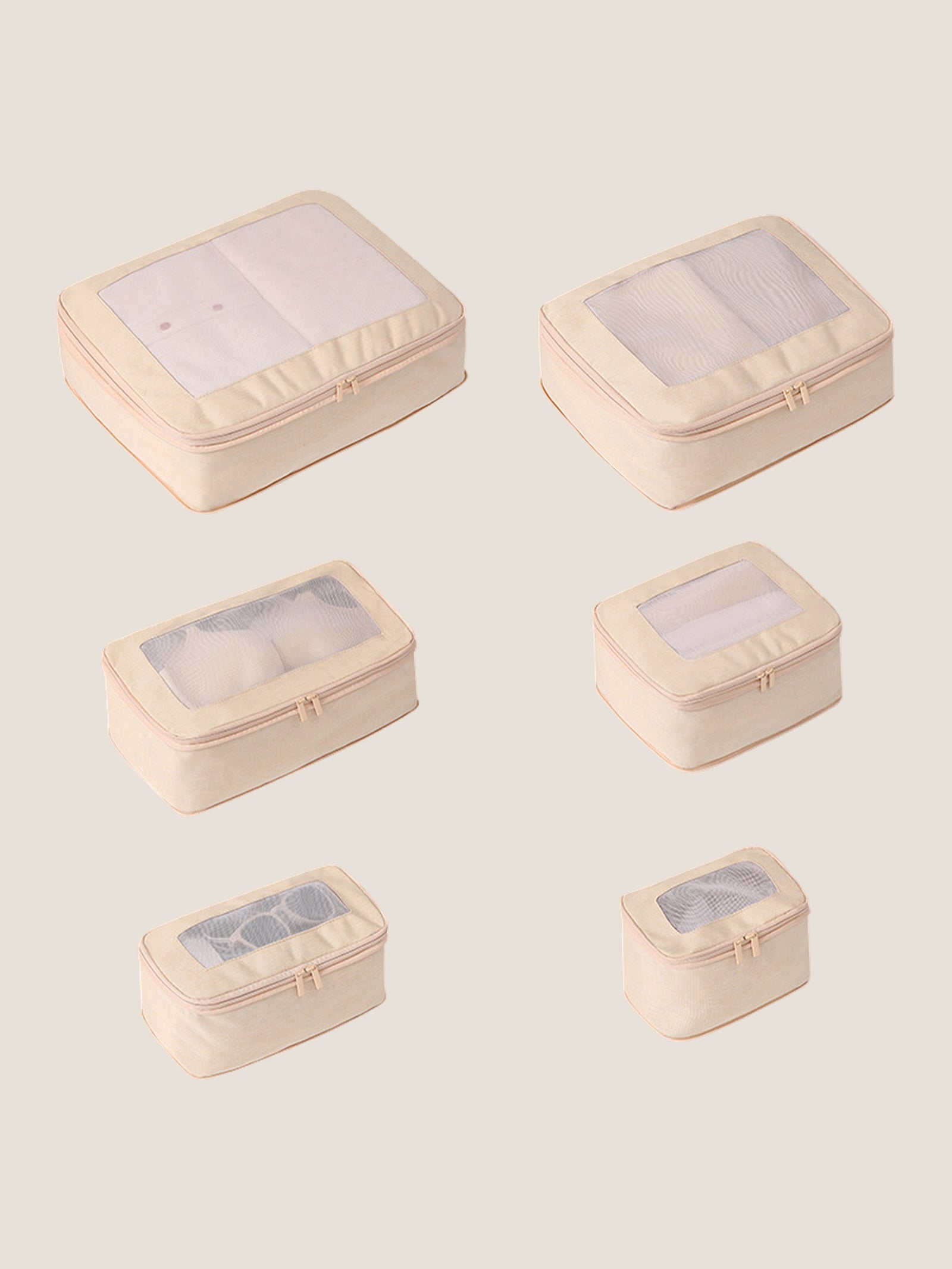 Set of six beige travel packing cubes with clear windows on a light beige background