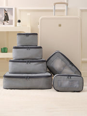 Set of gray packing cubes with a suitcase on a light-colored floor.