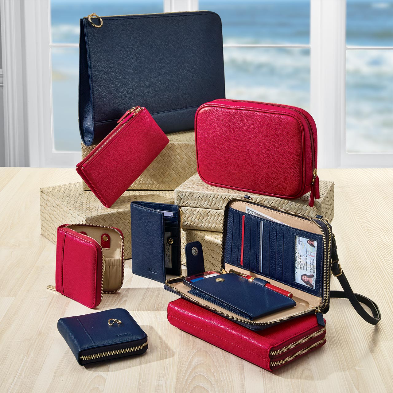 Collection of red and blue leather wallets and pouches on a wooden surface with a window view.