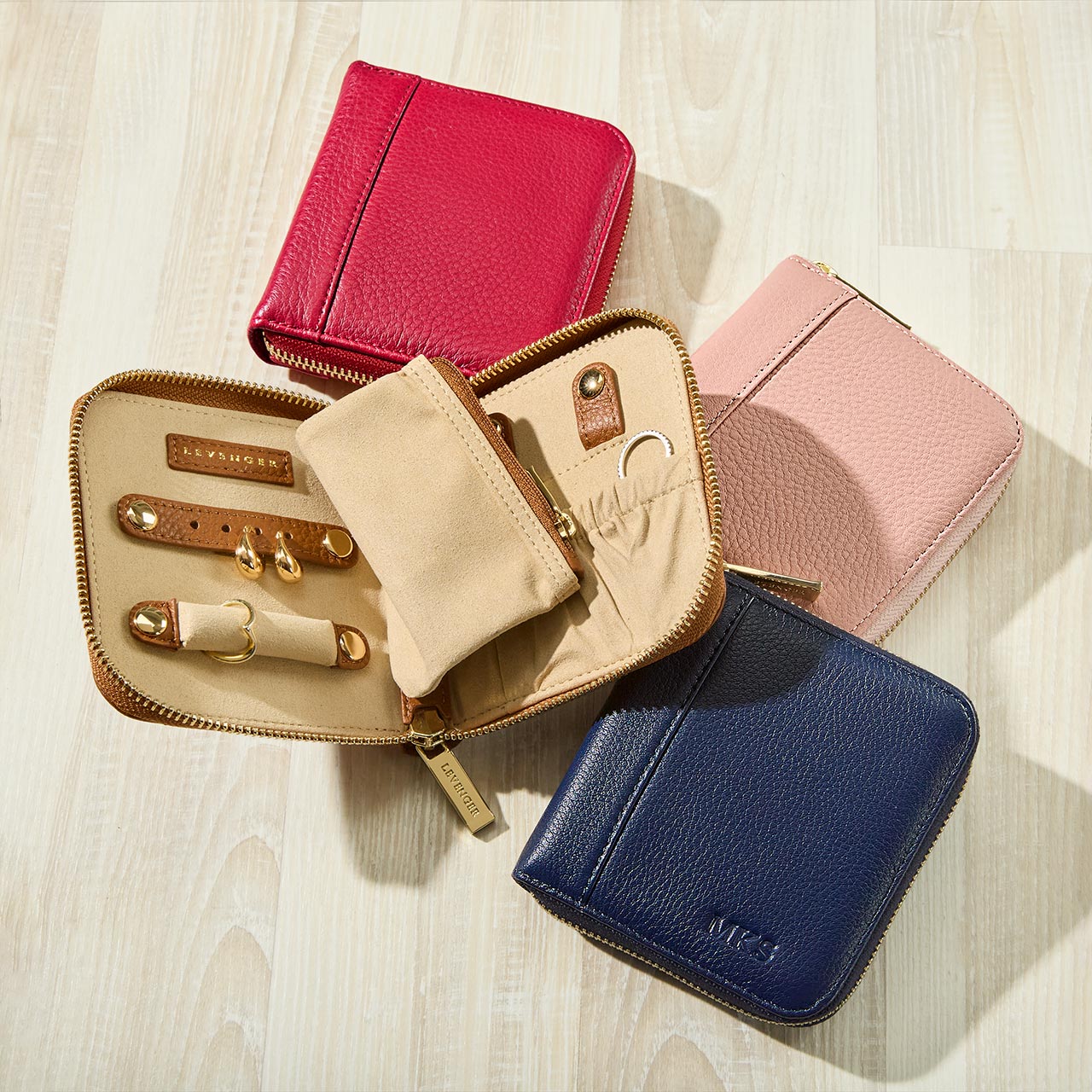 Collection of leather wallets in various colors on a light wooden surface