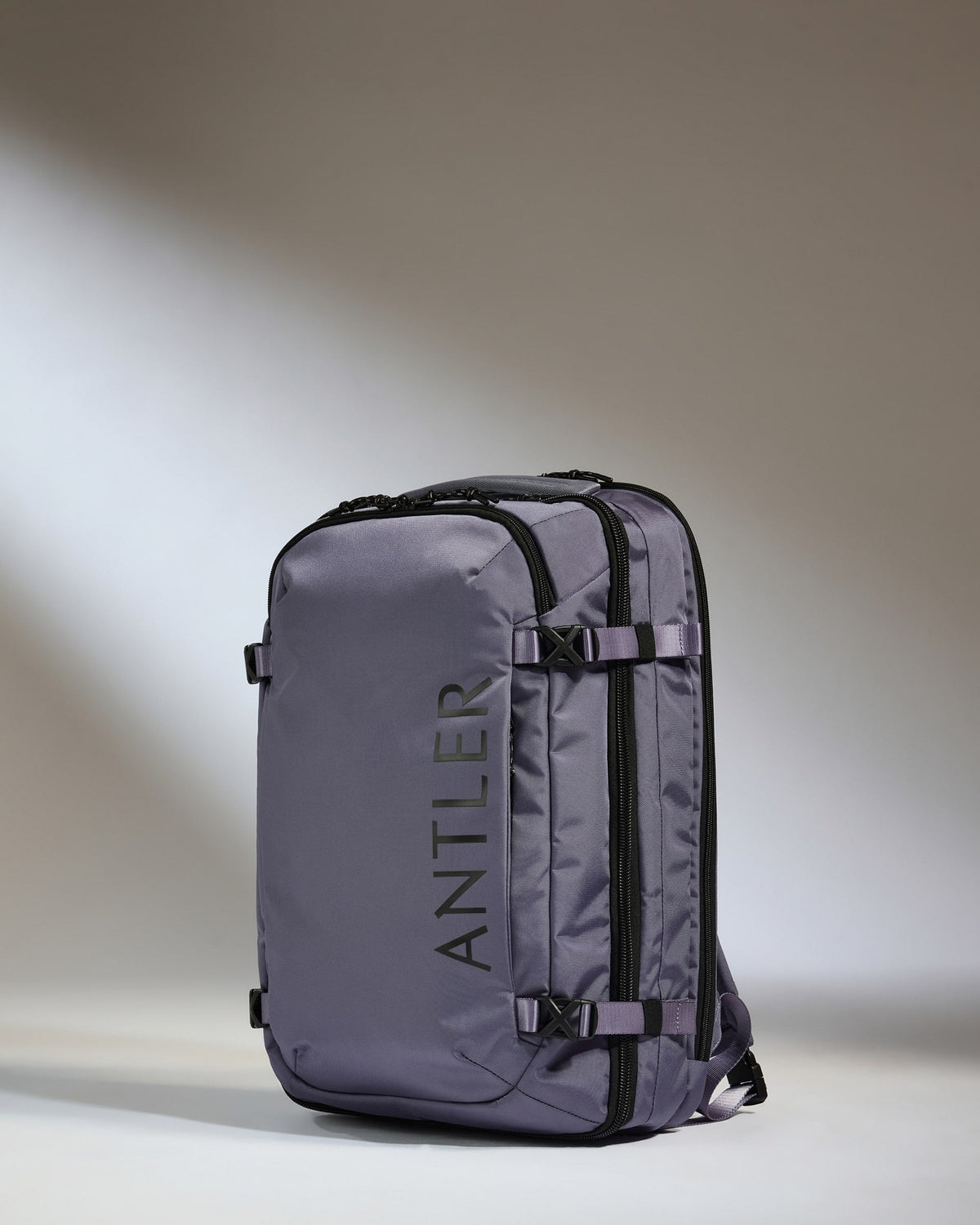 Gray backpack with 'ANTLER' branding on a gradient background