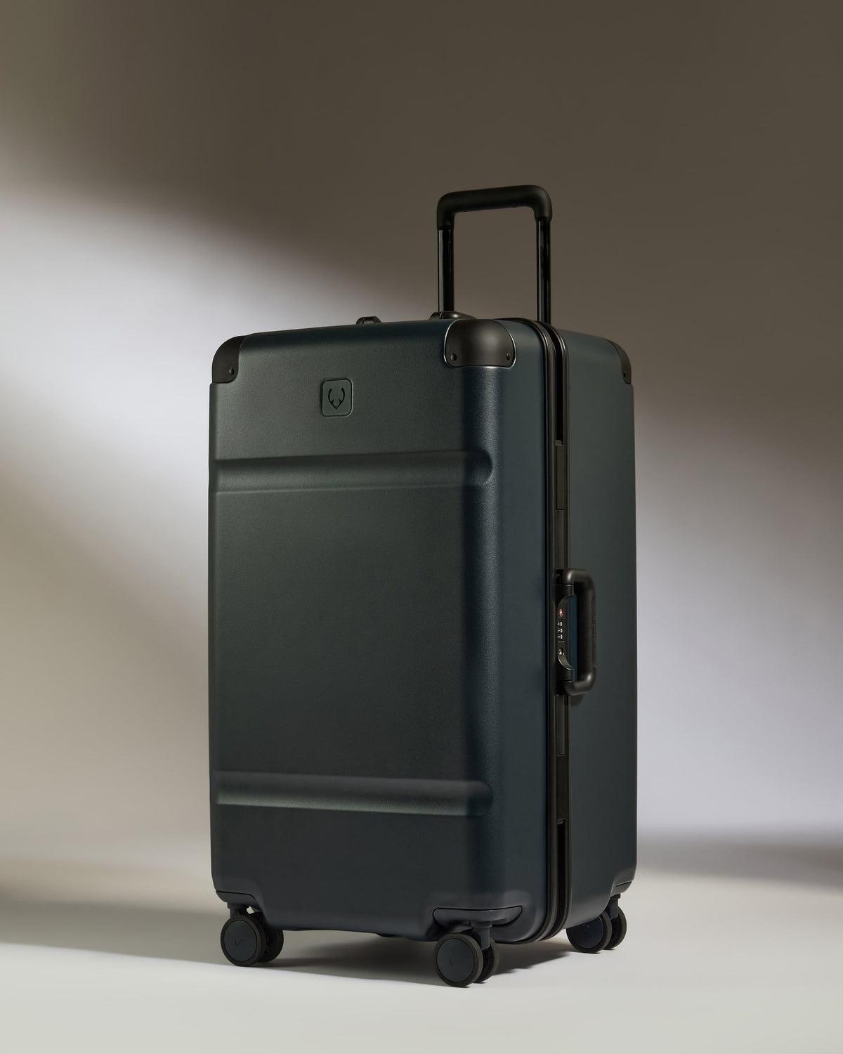 Black suitcase with a brand logo on a gradient background